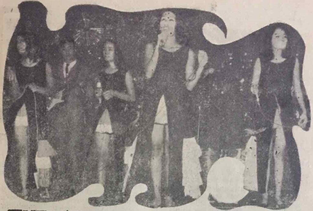 Piccolo gruppo di persone in cerchio con fogli in mano dentro una sala luminosa