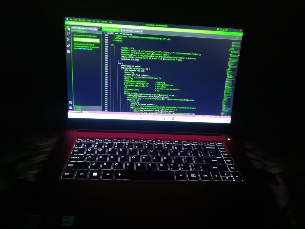 Schermo di un computer portatile acceso in una stanza in penombra, davanti a una sedia
