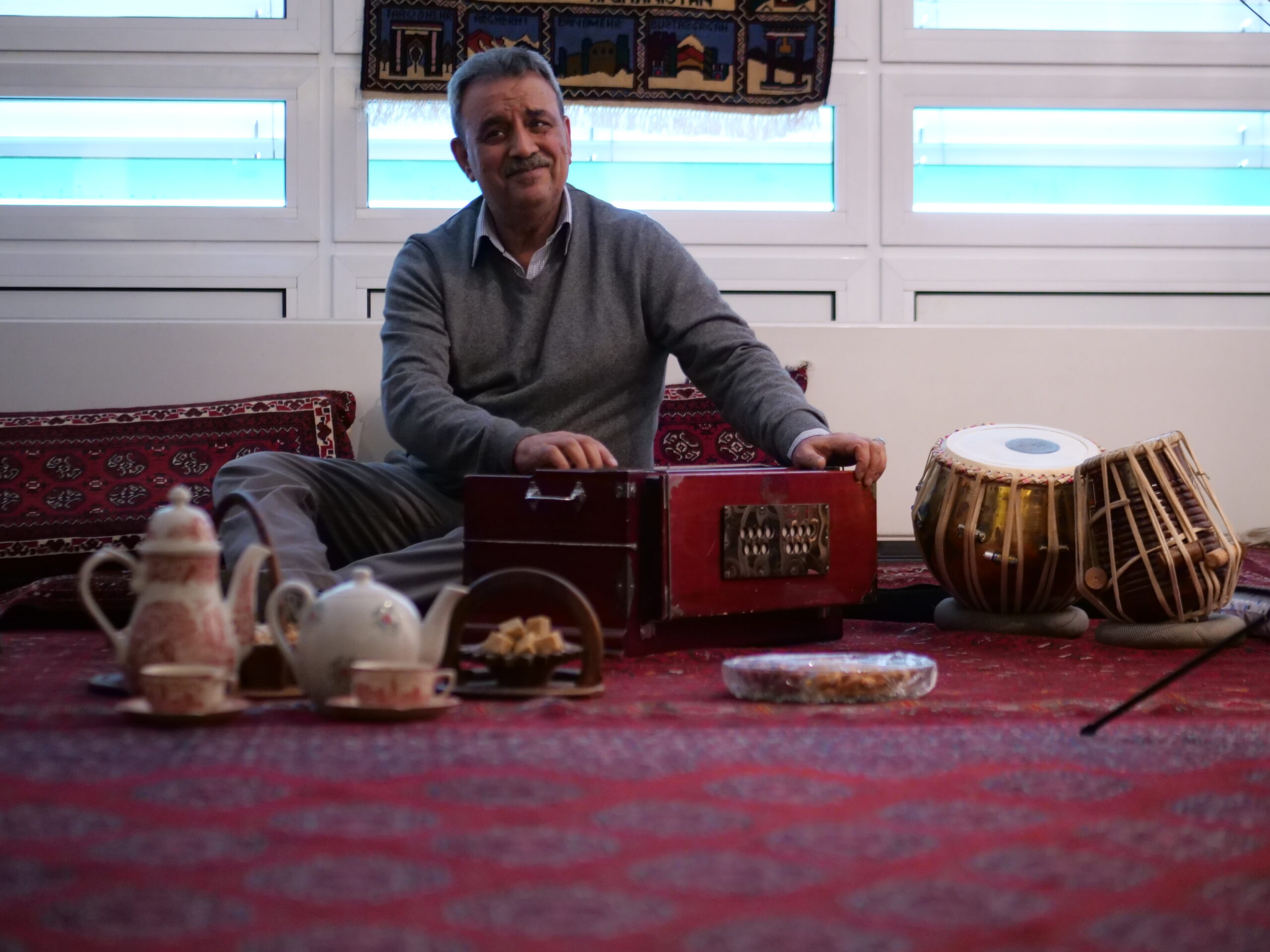 Harmonium e tabla appoggiati su un tappeto prima dell'inizio di una serata di canto