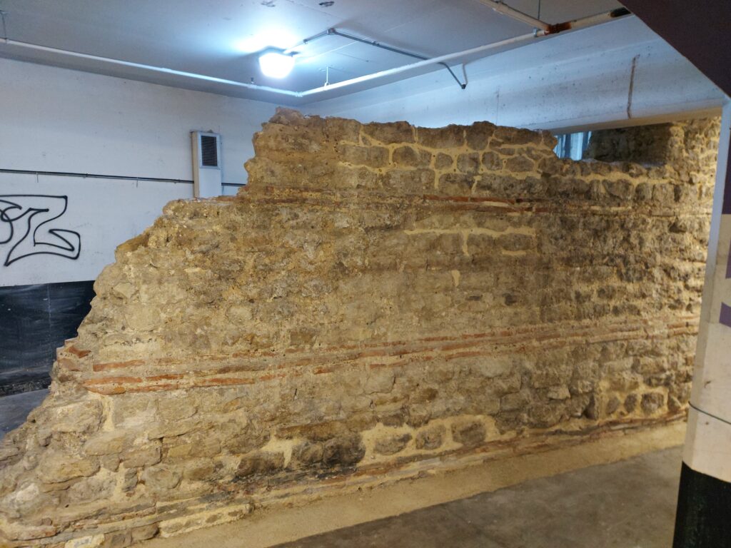 Ambiente sotterraneo in mattoni con volta bassa illuminato da una luce artificiale fioca